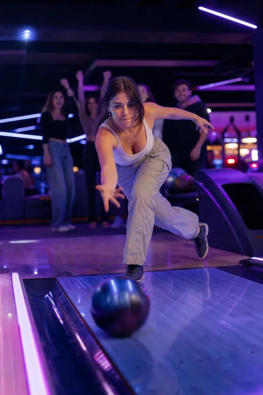 Someone bowling under neon lights