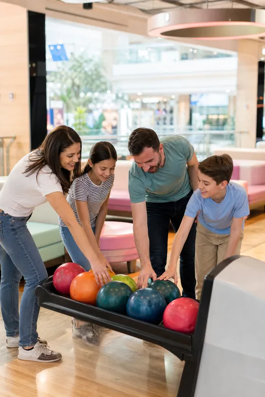 Friends picking up bowling balls